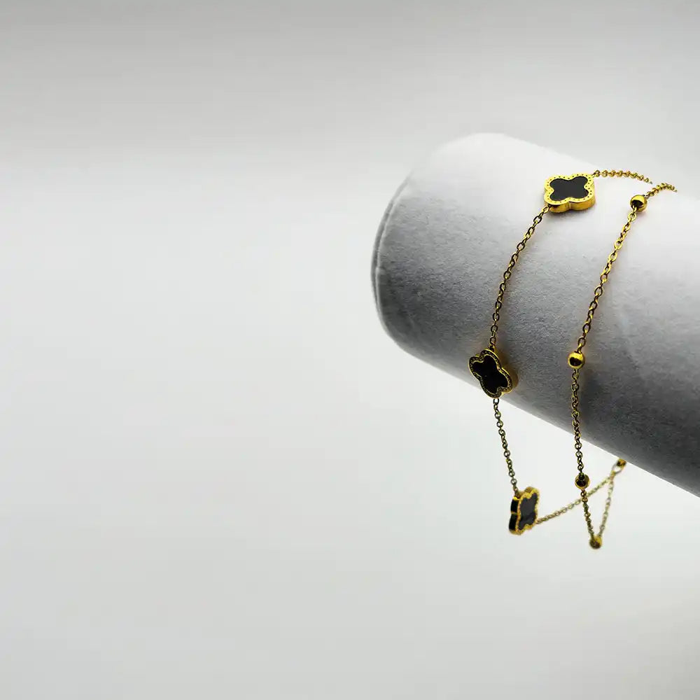 Gold chain with black clover charms.