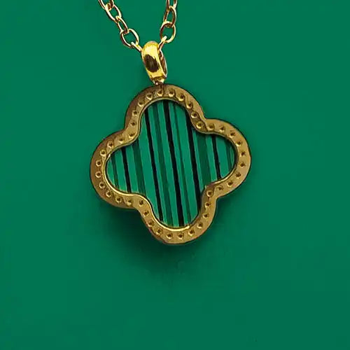 A gold clover-shaped pendant with vertical green and black stripes.